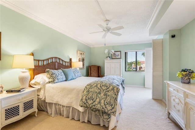 bedroom featuring a textured ceiling, ornamental molding, light colored carpet, and ceiling fan