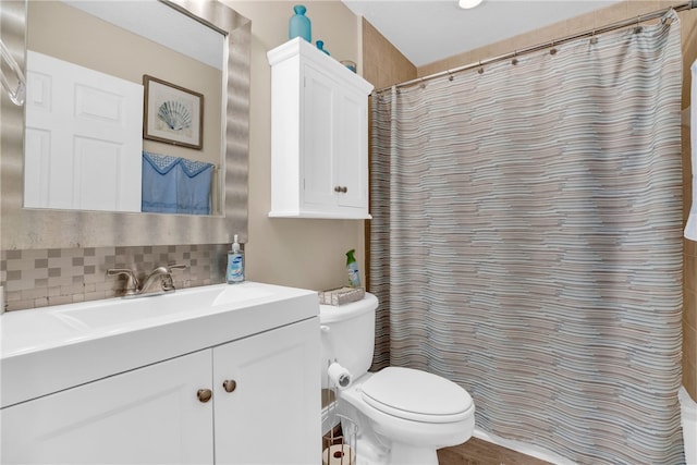 bathroom featuring tasteful backsplash, vanity, toilet, and curtained shower