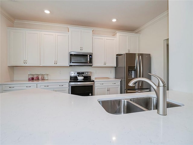 kitchen featuring white cabinetry, crown molding, appliances with stainless steel finishes, and a sink