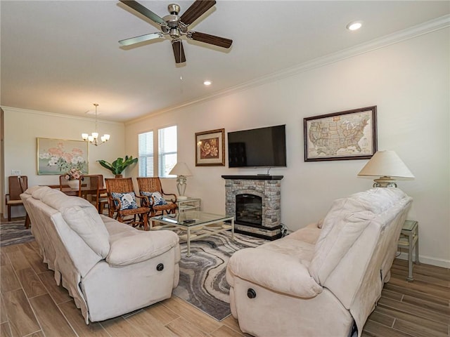 living room featuring ornamental molding, wood tiled floor, and ceiling fan with notable chandelier