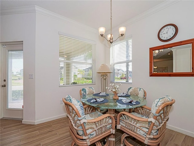 dining area with crown molding, a notable chandelier, and wood finished floors