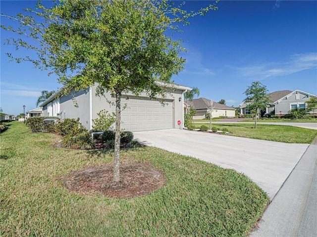 view of side of home with driveway, an attached garage, a yard, stucco siding, and a residential view