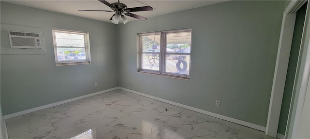 unfurnished room featuring light marble finish flooring, plenty of natural light, a wall mounted AC, and baseboards