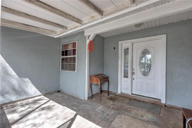 view of exterior entry with stucco siding