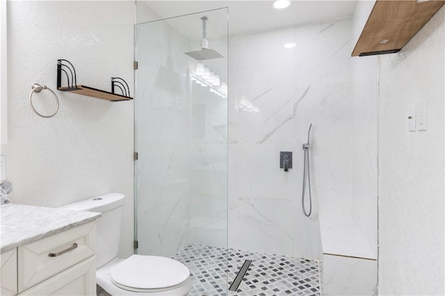 bathroom with vanity, toilet, and a tile shower