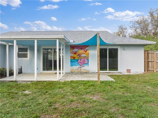 rear view of property with a patio and a lawn