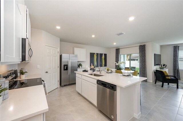 kitchen featuring a center island with sink, white cabinetry, stainless steel appliances, and a sink