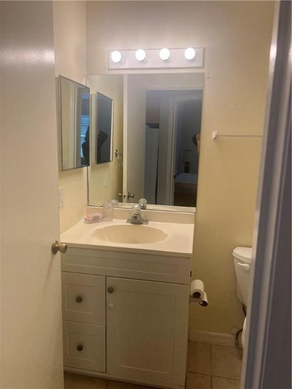 bathroom with toilet, tile patterned floors, and vanity