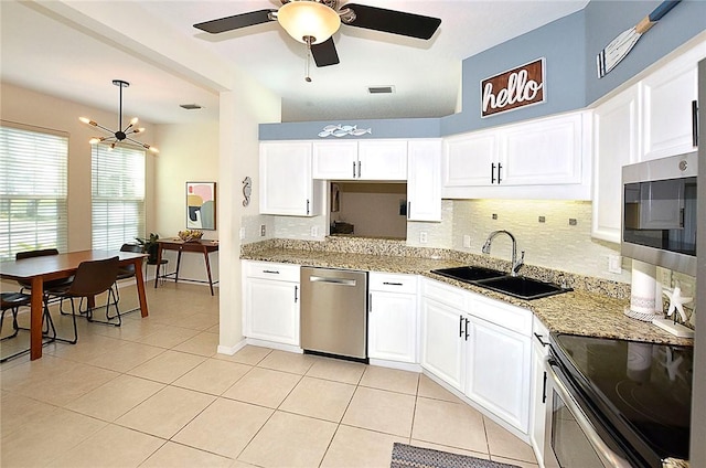 1910 Westminster Cir Unit 14-1, Vero Beach, FL 32966 - kitchen with a sink, stainless steel appliances, tasteful backsplash, light tile patterned floors, and light stone countertops