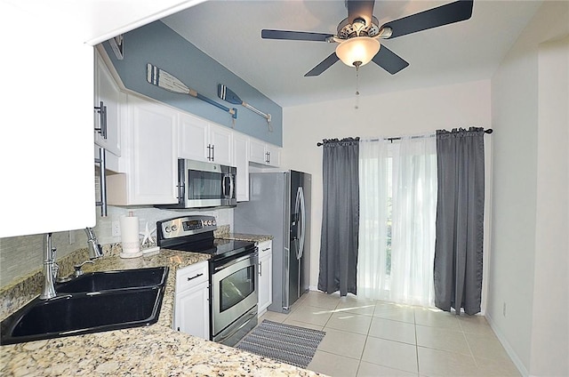 1910 Westminster Cir Unit 14-1, Vero Beach, FL 32966 - kitchen featuring appliances with stainless steel finishes, a sink, light tile patterned flooring, white cabinets, and decorative backsplash