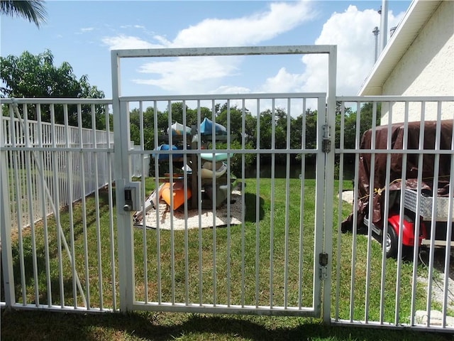 view of gate with a fenced backyard and a yard