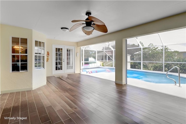 view of swimming pool with ceiling fan and french doors