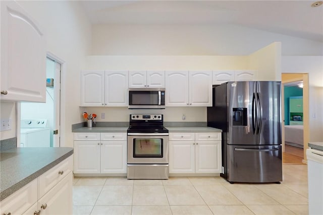 kitchen with appliances with stainless steel finishes, washer / clothes dryer, and white cabinetry