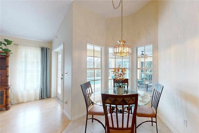 dining area with a healthy amount of sunlight, a high ceiling, and baseboards