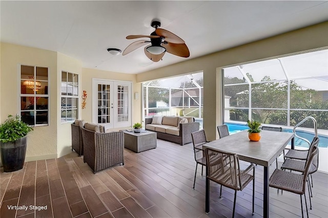 sunroom / solarium featuring ceiling fan and french doors