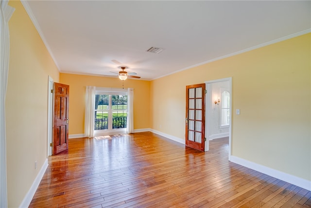 empty room with light hardwood / wood-style floors, ceiling fan, and crown molding