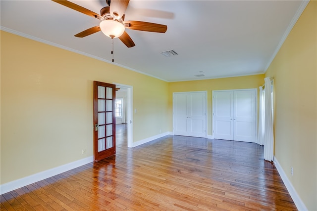 unfurnished bedroom featuring ceiling fan, light hardwood / wood-style floors, ornamental molding, and french doors