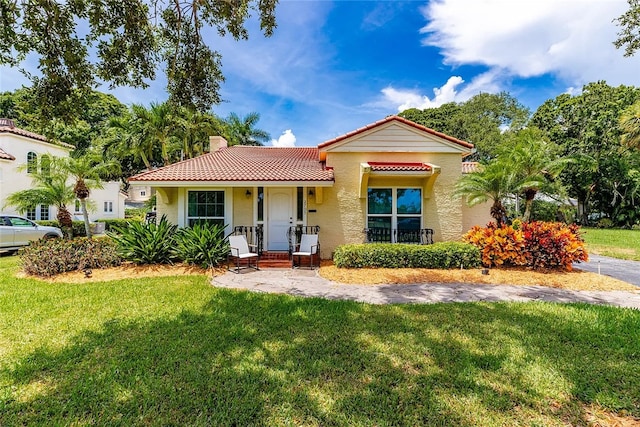 mediterranean / spanish-style home featuring a front lawn and a porch