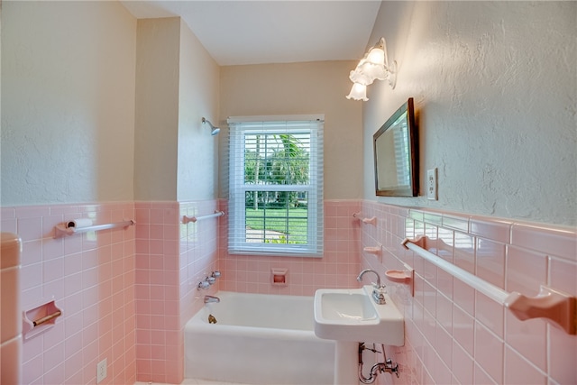 bathroom featuring a bathtub, sink, and tile walls