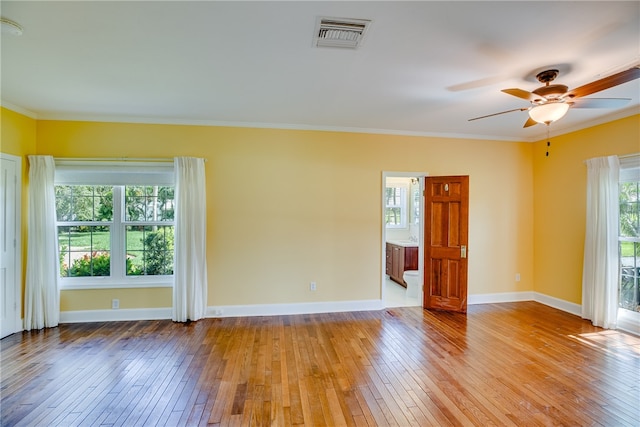 spare room featuring light wood-type flooring, ceiling fan, and ornamental molding