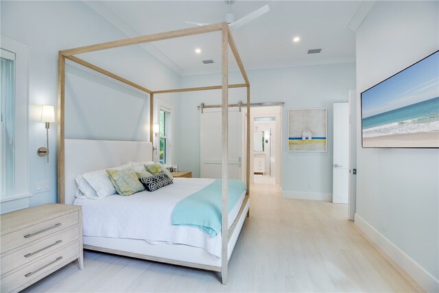 110 Mariner Beach Ln, Vero Beach, FL 32963 - bedroom with light wood-style floors and a barn door