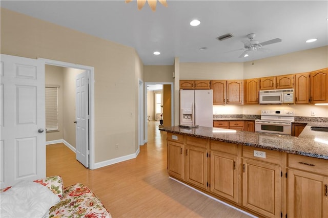 kitchen featuring sink, white appliances, dark stone countertops, ceiling fan, and light hardwood / wood-style floors