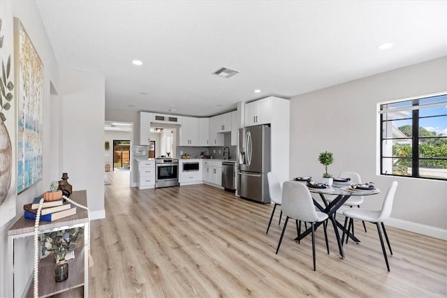 dining area featuring sink and light hardwood / wood-style flooring