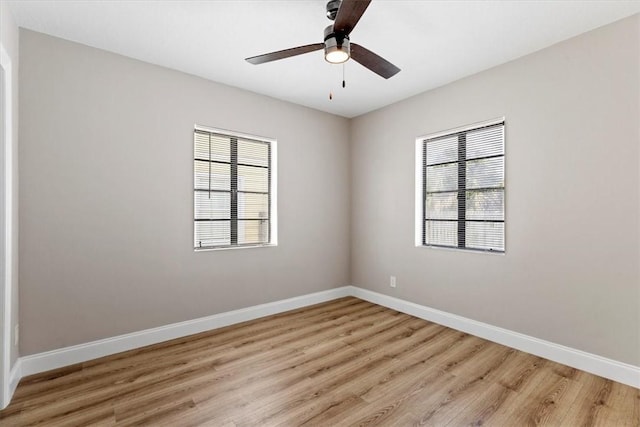 empty room with a wealth of natural light, ceiling fan, and light hardwood / wood-style flooring