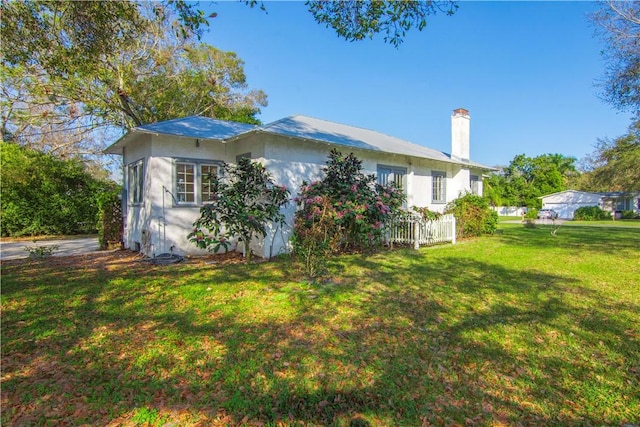 view of side of home with a yard