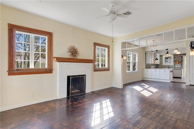 unfurnished living room featuring dark hardwood / wood-style flooring, ceiling fan, and a fireplace