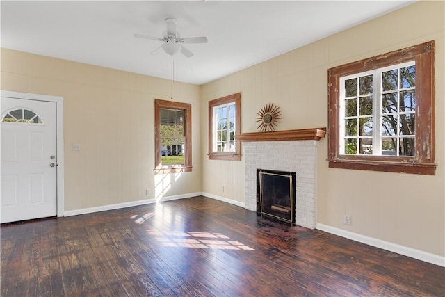 unfurnished living room with ceiling fan, a brick fireplace, and dark hardwood / wood-style flooring