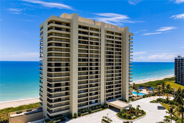 view of property with a beach view and a water view