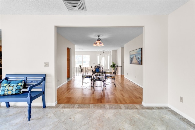 dining space featuring wood-type flooring and a textured ceiling