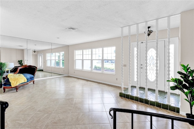 entryway featuring a textured ceiling and light tile patterned floors