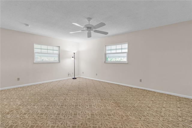 unfurnished room with ceiling fan, plenty of natural light, and a textured ceiling