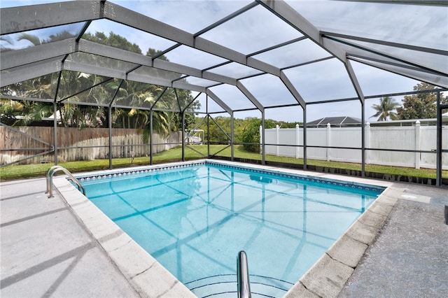 view of swimming pool with a yard and glass enclosure