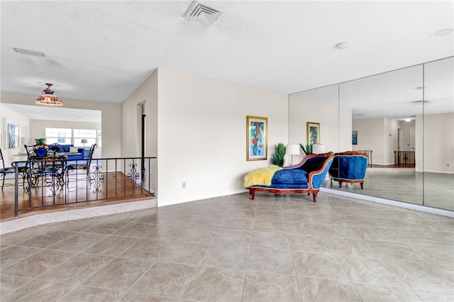 living area with light tile patterned flooring and a textured ceiling