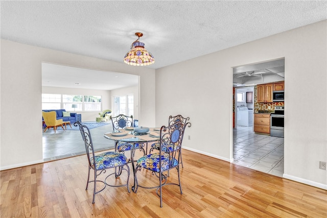 dining area with a textured ceiling and light wood-type flooring