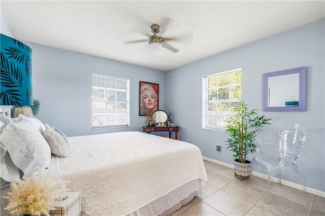 tiled bedroom featuring a textured ceiling, a ceiling fan, and baseboards