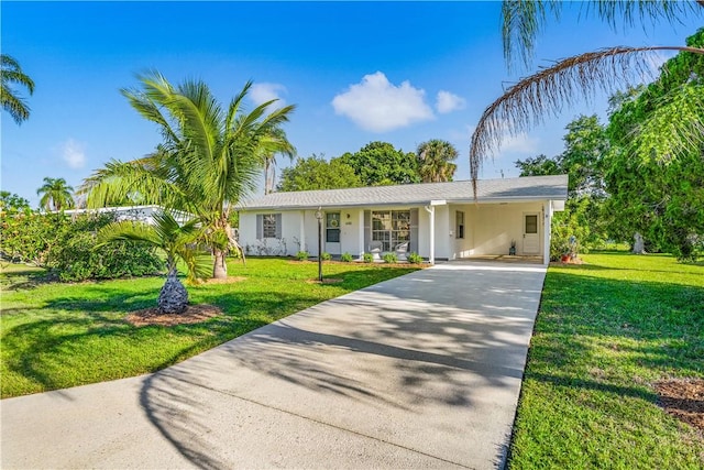 view of front of property with stucco siding, a front lawn, concrete driveway, and an attached carport