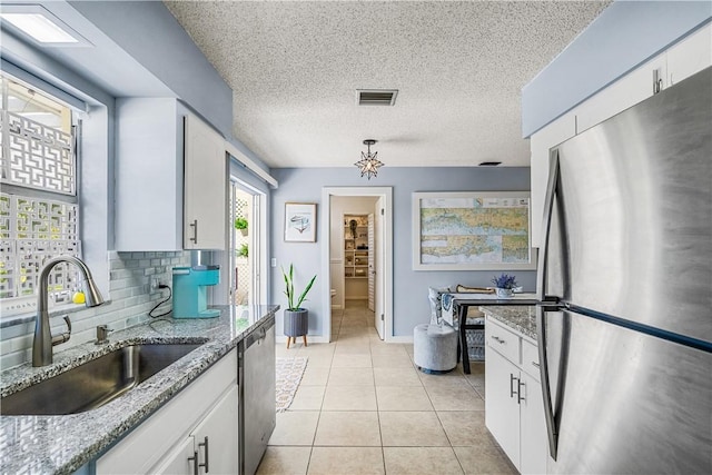 kitchen with white cabinetry, stainless steel appliances, visible vents, and a sink