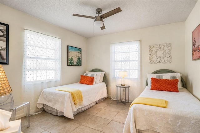 bedroom featuring a textured ceiling, multiple windows, and light tile patterned floors