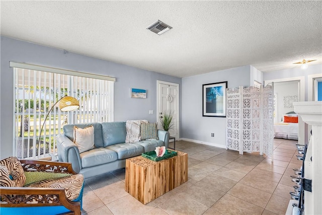living area featuring a textured ceiling, visible vents, and light tile patterned floors