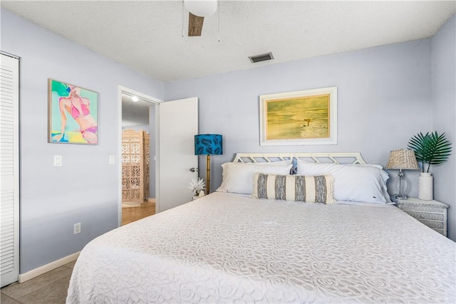 bedroom featuring baseboards, a ceiling fan, visible vents, and light tile patterned flooring