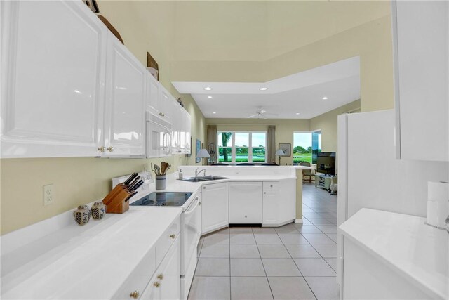 1725 Victoria Cir, Vero Beach, FL 32967 - kitchen featuring white cabinetry, white appliances, light tile patterned flooring, and a peninsula