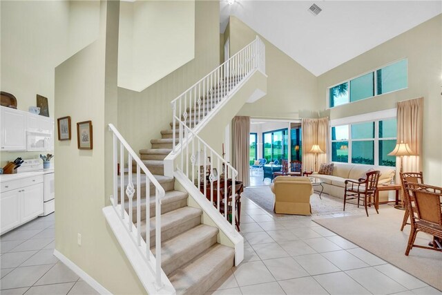 1725 Victoria Cir, Vero Beach, FL 32967 - stairs featuring tile patterned floors, visible vents, baseboards, and high vaulted ceiling