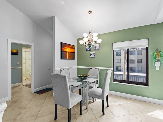 tiled dining room featuring lofted ceiling and an inviting chandelier