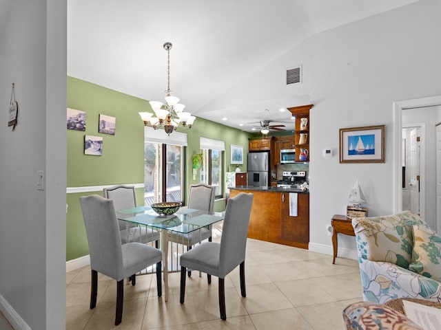 tiled dining room with ceiling fan with notable chandelier and vaulted ceiling