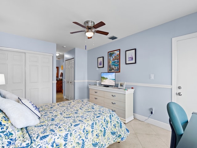 bedroom with ceiling fan, light tile patterned flooring, and two closets