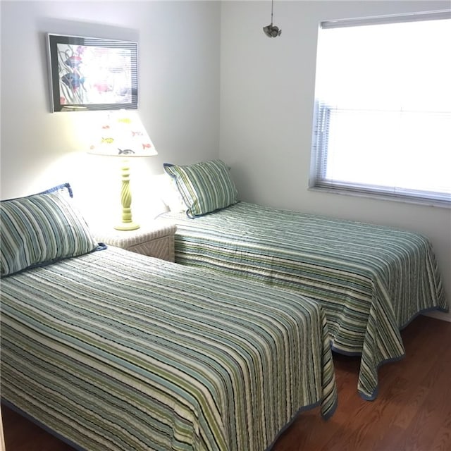 bedroom with dark wood-type flooring and multiple windows